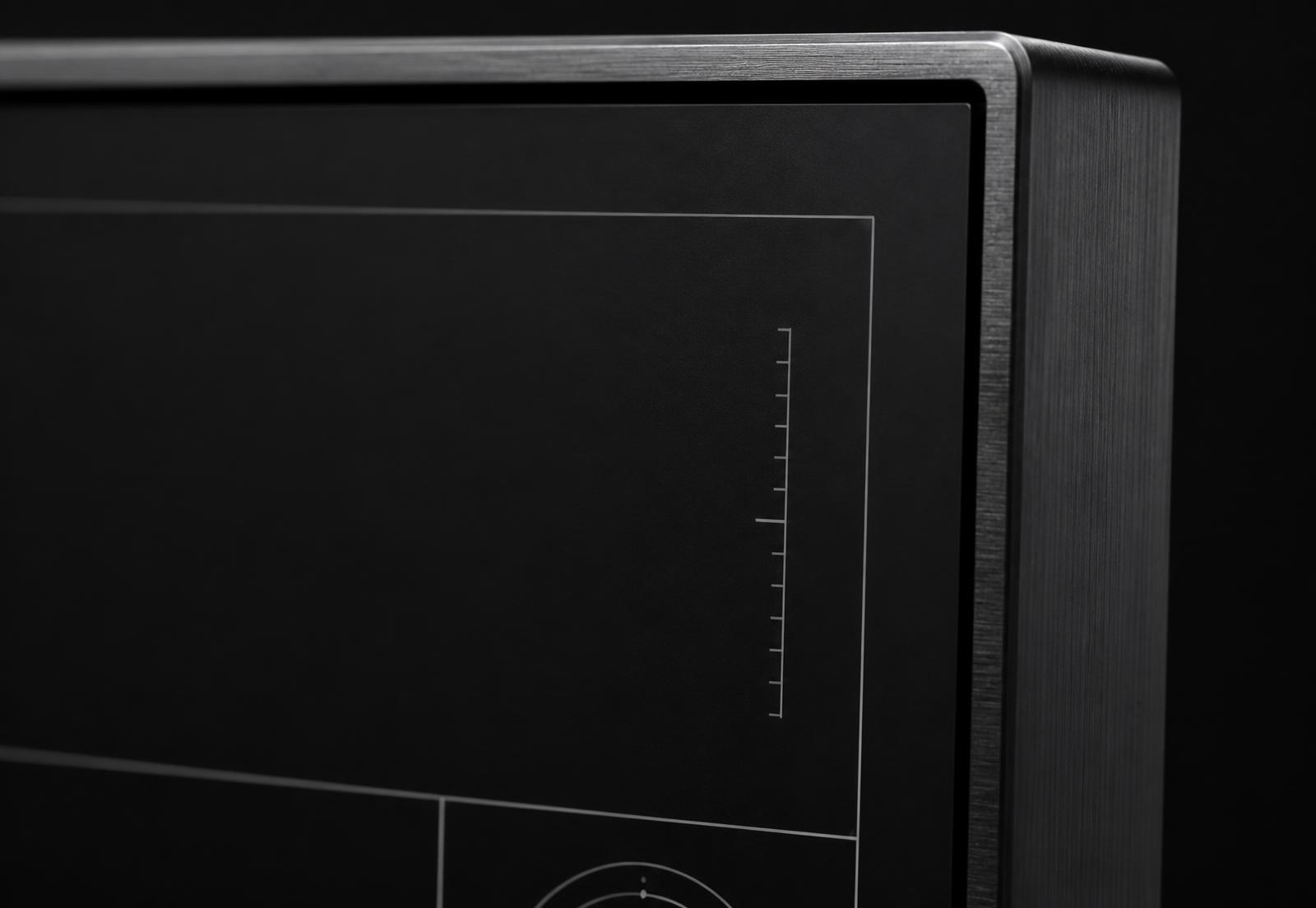 Close crop of a matte black display panel with fine hairline interface markings